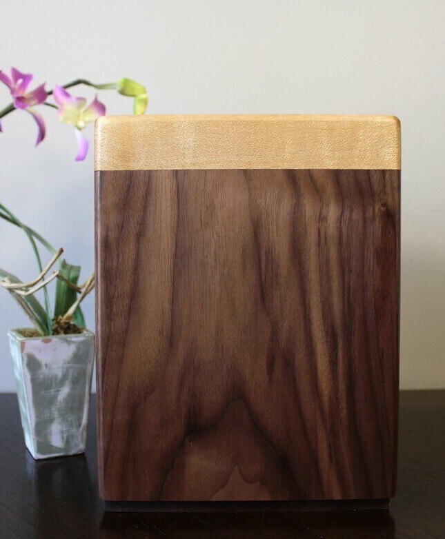 Right side view of a black walnut and figured maple wooden cremation urn