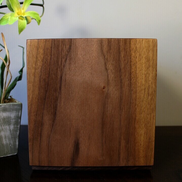 Front view of a boldly striped black Walnut wooden cremation urn