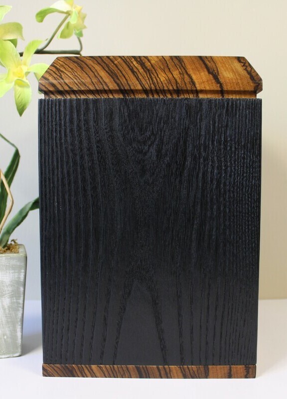 Right side view of a charred ash and zebrawood wooden cremation urn
