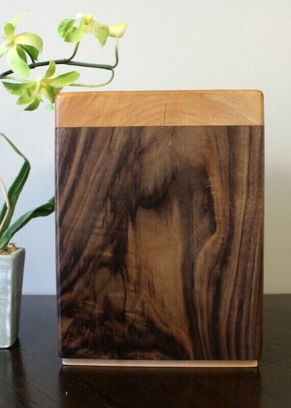 Left side view of a black walnut and flamed maple wooden cremation urn