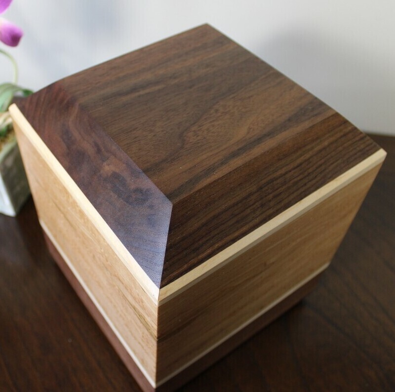 Top view of a bird's eye maple and black walnut wooden cremation urn