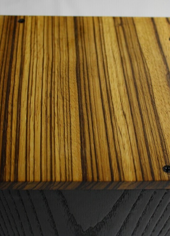 Bottom view of a charred ash and zebrawood wooden cremation urn