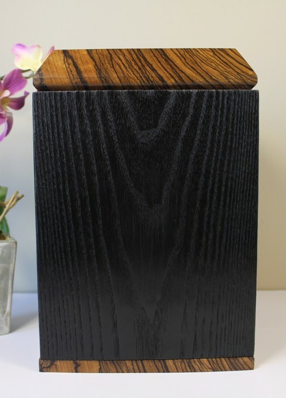 Right side view of a charred ash and zebrawood wooden cremation urn