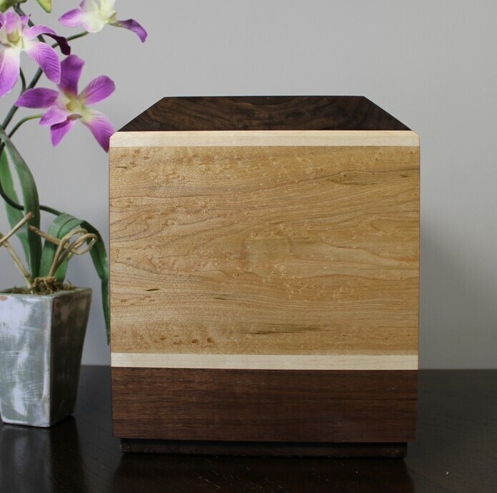 Back view of a bird's eye maple and black walnut wooden cremation urn