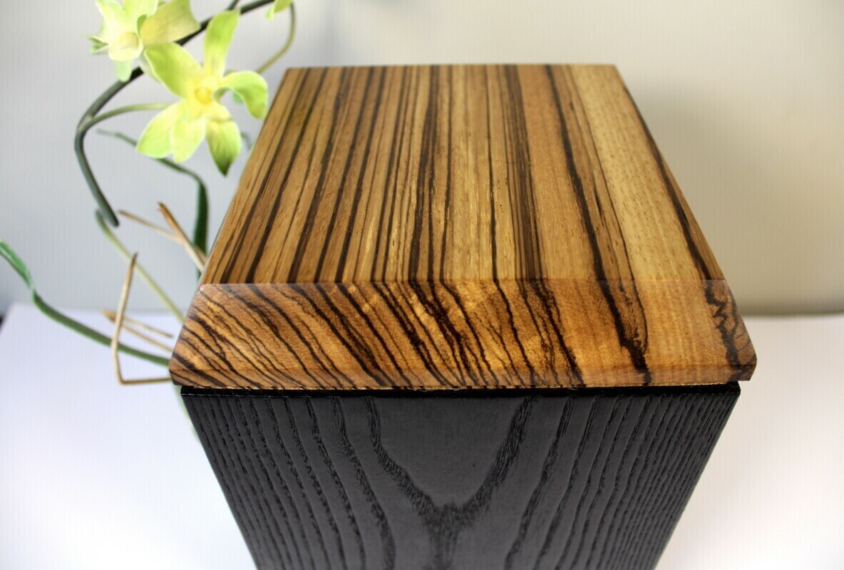 Top view of a charred ash and zebrawood wooden cremation urn