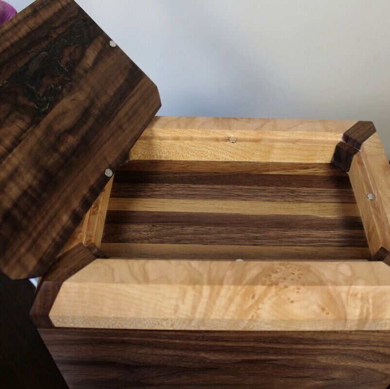 Alternate compartment view of a black walnut and figured maple wooden cremation urn