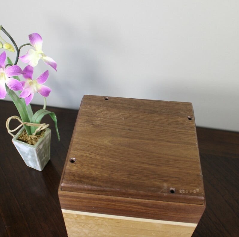 Bottom view of a bird's eye maple and black walnut wooden cremation urn
