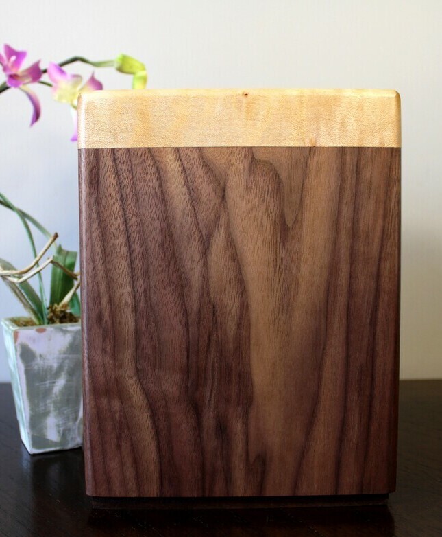 Back view of a black walnut and figured maple wooden cremation urn