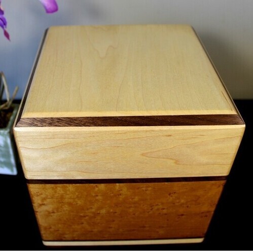 Top view of a light maple and torrefied bird's eye maple wooden cremation urn