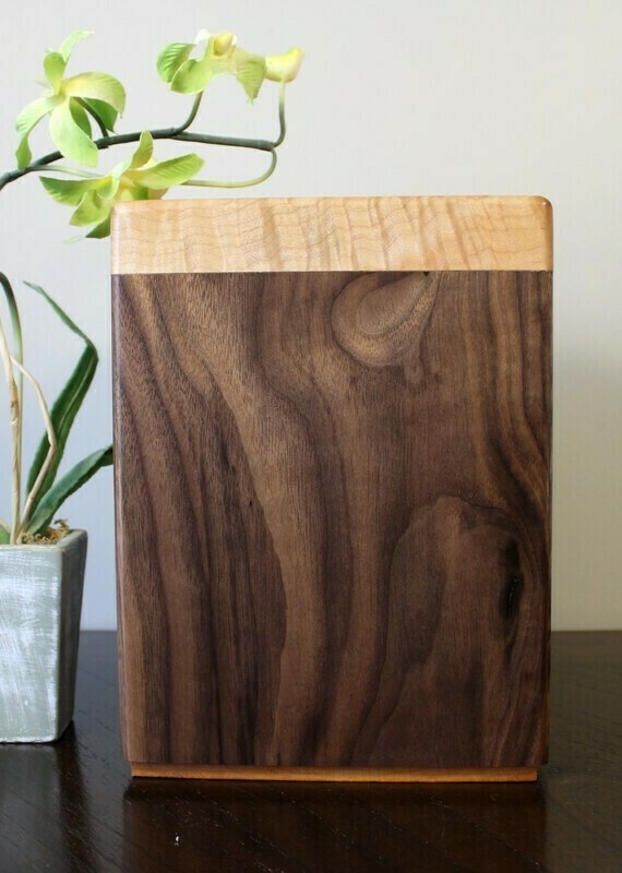 Front view of a black walnut and flamed maple wooden cremation urn