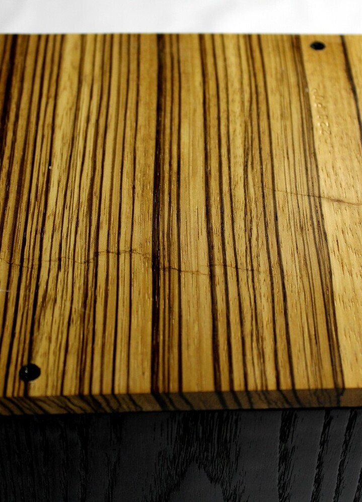 Bottom view of a charred ash and zebrawood wooden cremation urn