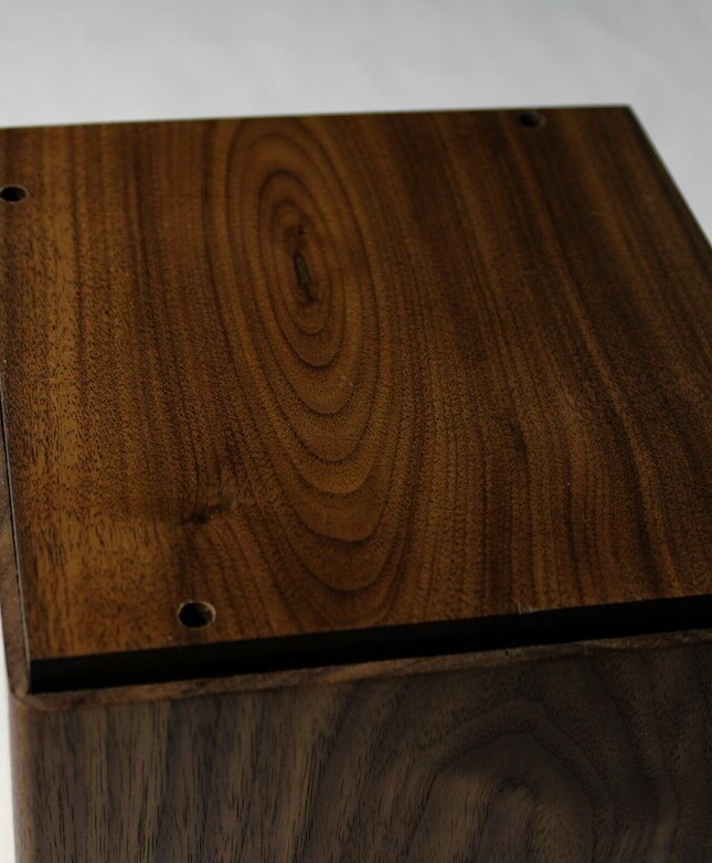 Bottom view of a black walnut and figured maple wooden cremation urn
