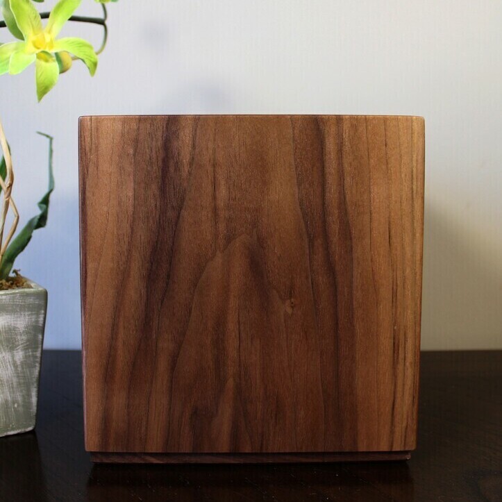 Left side view of a boldly striped black Walnut wooden cremation urn