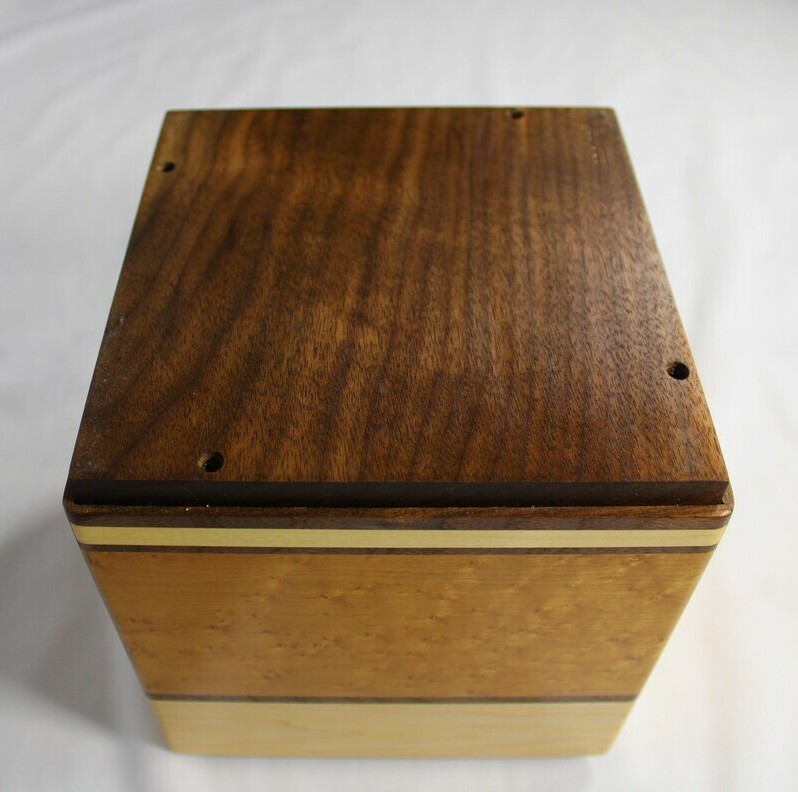 Bottom view of a light maple and torrefied bird's eye maple wooden cremation urn