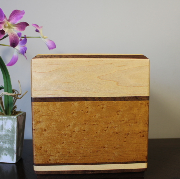 Right side view of a light maple and torrefied bird's eye maple wooden cremation urn