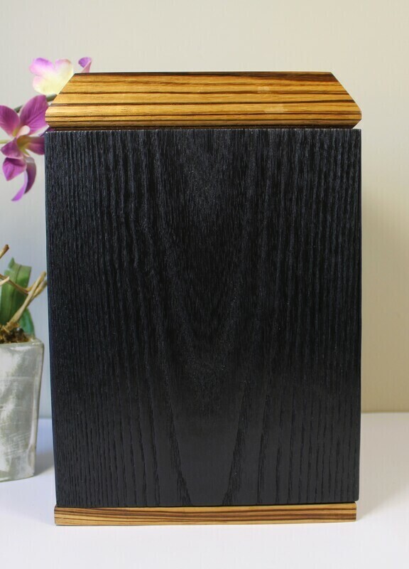 Back view of a charred ash and zebrawood wooden cremation urn