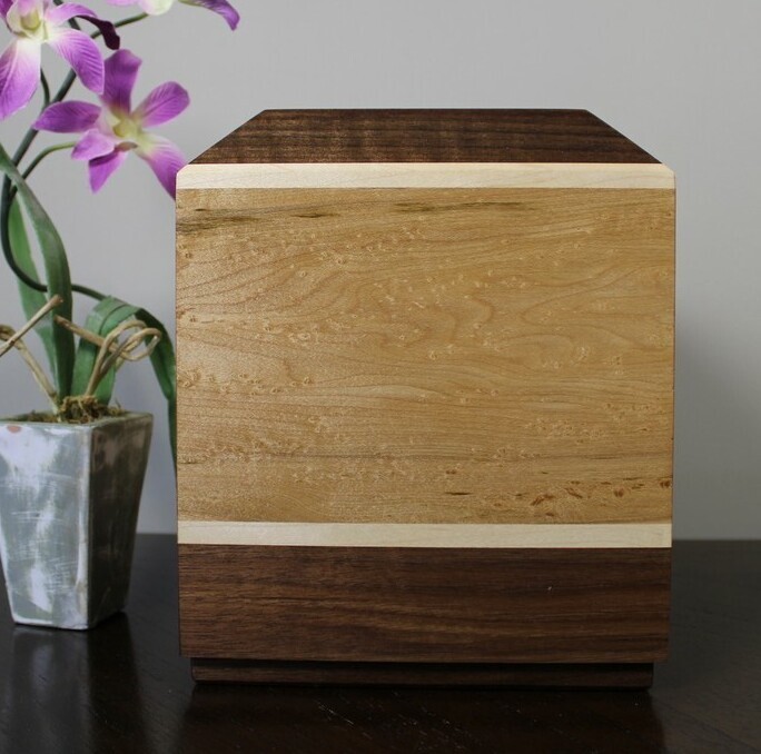 Right side view of a bird's eye maple and black walnut wooden cremation urn