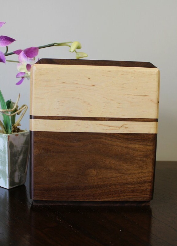 Front view of a Black walnut and maple with subtle speckles wooden cremation urn