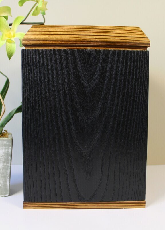 Back view of a charred ash and zebrawood wooden cremation urn