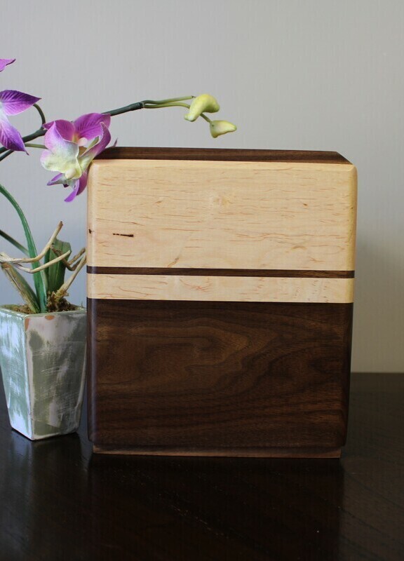 Left side view of a Black walnut and maple with subtle speckles wooden cremation urn
