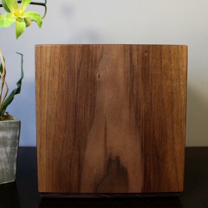 Back view of a boldly striped black Walnut wooden cremation urn