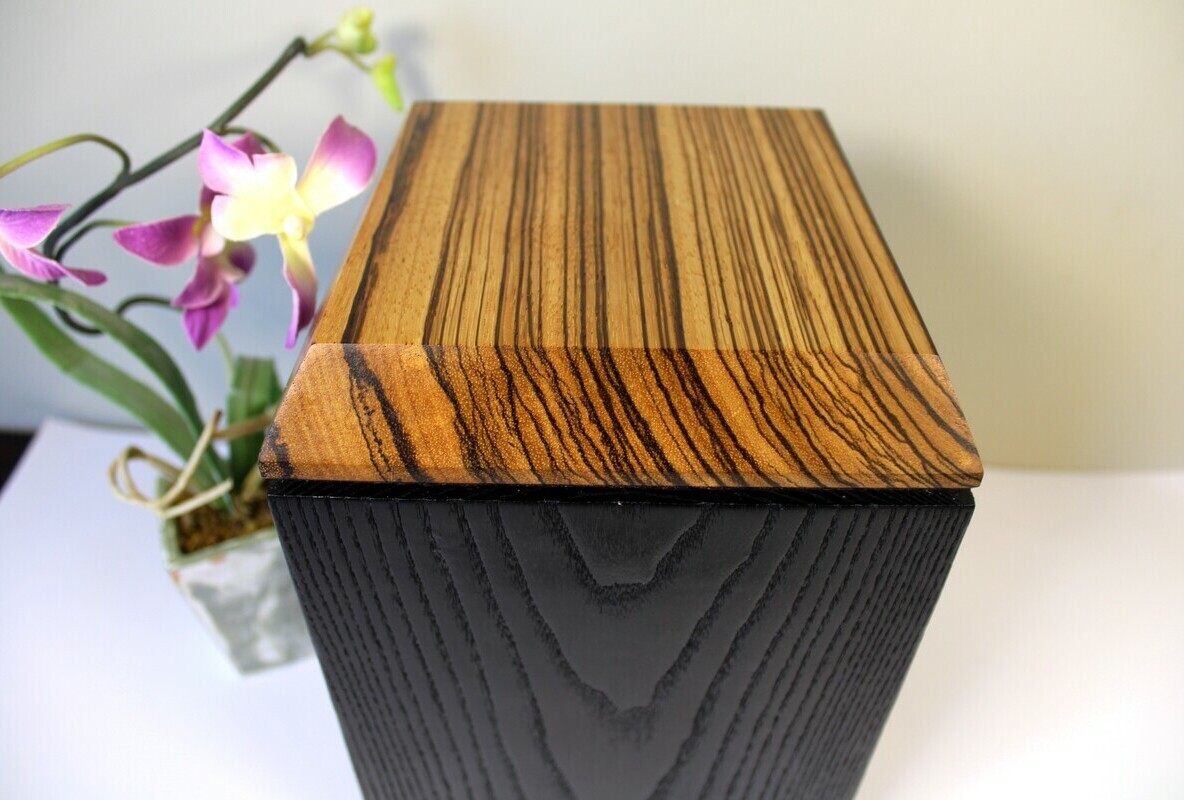Top view of a charred ash and zebrawood wooden cremation urn