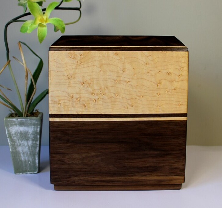 Right side view of a black walnut and bird's eye maple wooden cremation urn