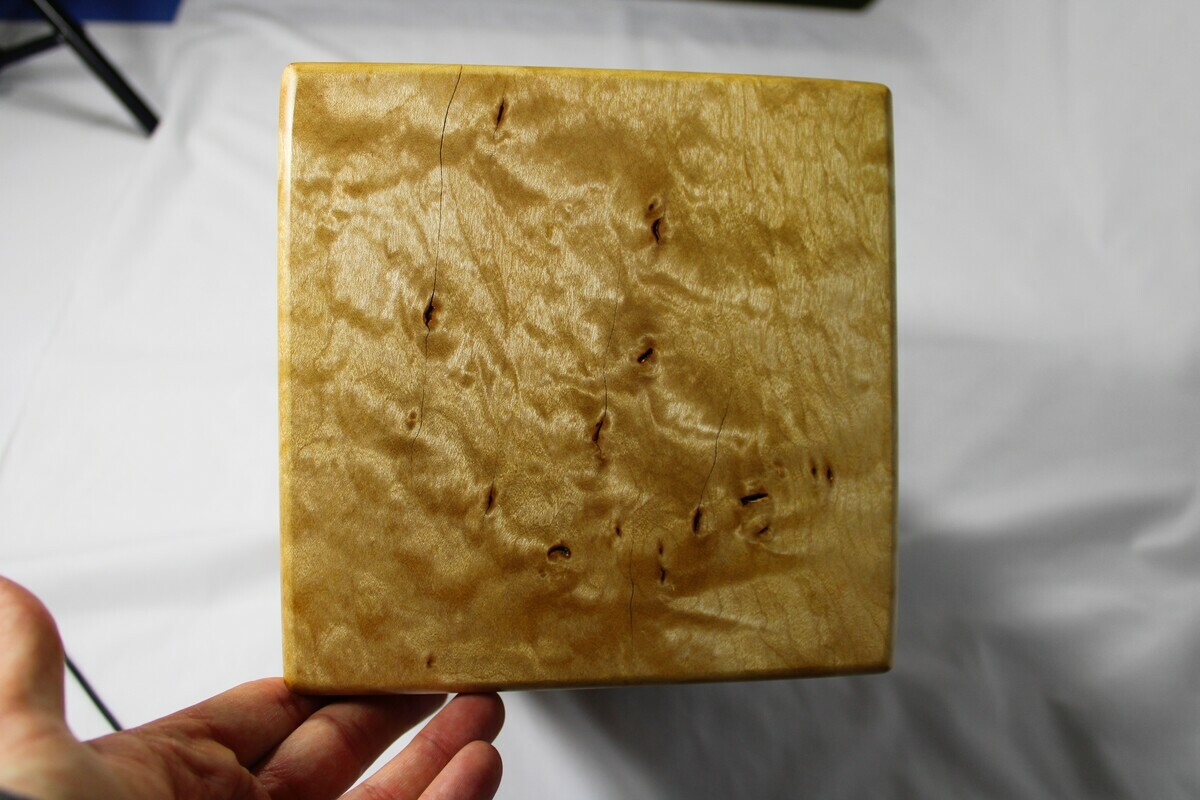 Top view of a figured maple wooden cremation urn